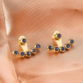 Dettaglio di orecchini dorati con cristalli blu su tessuto di raso in oro rosa - N. 195 Blu / Blu