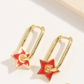 Macro-opname van minimalistische gouden U-oorbellen met rode emaille sterhangers - Rood