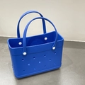Detailed view of a bright blue lightweight EVA beach bag with signature holes and rivets - Blue