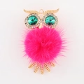 Gros plan détaillé du pendentif hibou avec pompon rose et yeux en cristaux verts étincelants - Rouge Rose