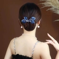 Pince à cheveux papillon en cristal bleu élégante sur un chignon sophistiqué - Feuille en Cristal Bleu