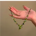 Détail du collier de perles avec pendentif Wu Lou vert et breloques de fleurs - Floral vert