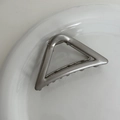 Close-up of minimalist silver metal triangular hair claw clip on white ceramic plate - Grey Silver - Small Triangle