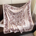 Detailed texture of bamboo leaf print silk scarf draped on a vintage leather sofa - Lotus root pink