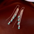 Détail de boucles d'oreilles à franges dorées avec zircons bleu lac et blanc en goutte - Fil d'oreille-Or-Bleu