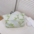 Détail de broderie jacquard oiseau et étiquette 'simple wish' sur trousse vert clair - Branches Vertes Oiseau de Soie d'Or