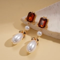 Detalle de pendiente dorado vintage con gema roja y perla en forma de lágrima - Poste de plata para pendientes - Café
