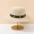 Dettaglio cappello di paglia beige con nastro leopardato e borchie a croce d'argento - Stile Beige Con Stampa Leopardata