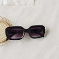 Detailaufnahme der schwarzen quadratischen Sonnenbrille mit lila Verlaufsgläsern auf weißem Grund - Schwarzer Rahmen Doppelgrau