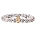 Macro detail of white marble turquoise beaded bracelet with elephant charm on plain background - White Howlite Bracelet