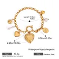 Dettaglio del bracciale a catena dorata in acciaio con perla barocca e ciondoli a cuore - Oro