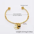 Dettaglio di un bracciale rigido in acciaio inossidabile placcato oro 18k con ciondolo - Campanello Oro Piastra Rotonda (Z395)