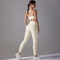Detailoverzicht van de beige rugloze sportbeha en de high-waisted yoga legging - S / Licht Ivoor