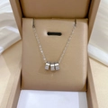 Close-up of silver punk necklace with triple Roman numeral rings in a premium gift box - Silver