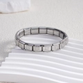 Close-up of stainless steel Italian charm bracelet with embossed floral cross patterns - Daisy Silver (BD-148)