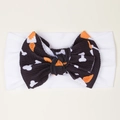 Detail of white waffle knit baby headband featuring Halloween pumpkin bow patterns - White