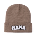 Detailed view of MAMA towel embroidery patch on brown knitted beanie with texture - Camel