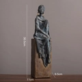 Modern abstract seated figure sculpture with bronze texture on a wooden pedestal - Sitting Style B