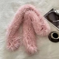 Detalle de una suave bufanda de piel sintética rosa sobre mesa con revista y café - Rosa con flecos largos