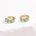 Detailed close-up of gold hoop earrings with five blue enamel star charms on stone - Star - Blue