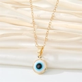 Golden titanium steel necklace with a blue evil eye pendant on silk fabric background - 18K Gold / White Necklace