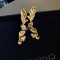 Gros plan détaillé de boucles d'oreilles dorées à texture lave sur coffret noir - Boucles d'oreilles dorées