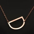 Minimalist D-shaped rose gold necklace with brushed metal finish on cross chain - Rose Gold D