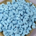 Dettaglio di perline a lettere in resina azzurra in una ciotola per creazioni fai-da-te - Dolcetto o Scherzetto / Confezione singola casuale / Blu