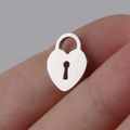 Detailed macro shot of a mini heart-shaped lock pendant in polished stainless steel - Lock / Steel