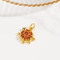Detailed view of a gold turtle pendant set with red cubic zirconia crystals and a loop - Red (Turtle Style B)