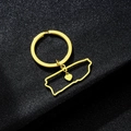 Detailopname van de gouden Puerto Rico kaart sleutelhanger met hart op zwarte ondergrond - Gouden Hol Hart