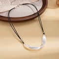 Detail of matte silver irregular curved pendant necklace on decorative vintage background - Silver
