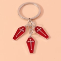Dettaglio di tre ciondoli a bara rossi con croci argentate su un portachiavi in metallo - Argento Rosso / Rosso