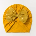Close-up of ginger baby turban hat with a large gold polka dot bow detail on plain background - Khaki/Earth Yellow