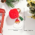 Portachiavi Babbo Natale con pompon rosso e nappa verde in un ambiente festivo - Pompon di Natale