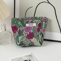 Close-up of floral embroidered cosmetic bag with purple flowers and woven brand label - Small / Purple Flowers