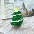 Glitzernde grüne Weihnachtsbaum-Haarklammer mit gelbem Stern auf festlichem Hintergrund - Weihnachtsbaum Haarklammer
