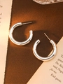 Detailed view of silver C-shaped irregular earrings on a vintage paper background - Silver Large C-Shape