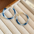 Macro detail of blue gradient cotton thread wrapped around large gold hoop earrings - Silver Needle - Blue Gradient