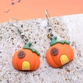 Handcrafted pumpkin house resin earrings with green stems on stone surface - Pumpkin House