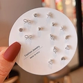 Close-up of a 7-piece silver stud earring set with stars and bows on round card - Silver Butterfly Heart Set (E0020-1)