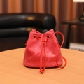 Sac seau rouge en tissu texturé avec cordon de serrage sur une table en bois - Rouge