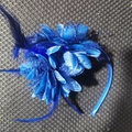Detailed top view of the blue fabric flower and feather fascinator on a headband - Blue