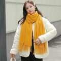 Thick yellow cashmere scarf with tassels styled on a model in an outdoor city setting - 200*70cm / Velvet-Touch Tassel Style / Ginger Yellow