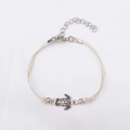 Détail du charm tortue sur bracelet de cheville tressé crème avec fermoir ajustable - Blanc Cassé - Style Chaîne d'Extension