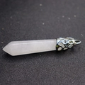 Primer plano de un colgante hexagonal de cristal blanco con cierre de plata sobre fondo oscuro - Cristal de roca