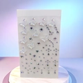 Detail of iridescent butterfly stickers and AB rhinestones on a marble display base - New Butterfly White AB