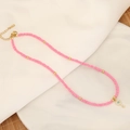 Böhmische rosa Perlenkette mit goldenem Evil Eye Schlüsselanhänger auf einem weißen Teller - Wassermelonenrot Schlüssel Böser Blick Stil