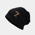 Detalle de un gorro de punto negro con etiqueta de cuero 7th y estilo urbano chic - Talla única / Negro