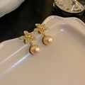 Macro shot of gold starfish earrings with sparkling zircon and champagne pearl detail - Champagne Starfish Zirconia Pearl Style